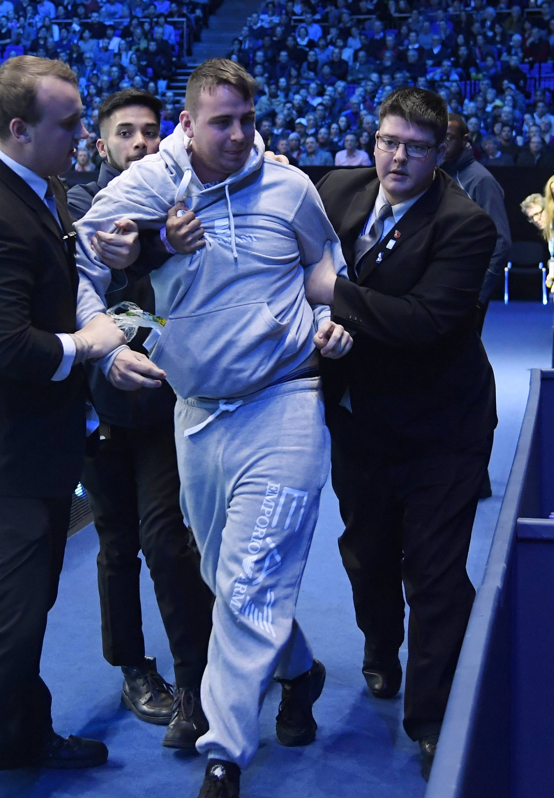 Security apprehend a spectator that attempted to invade the court during the semi final match between Japan's Kei Nishikori and Serbia's Novak Djokovic
