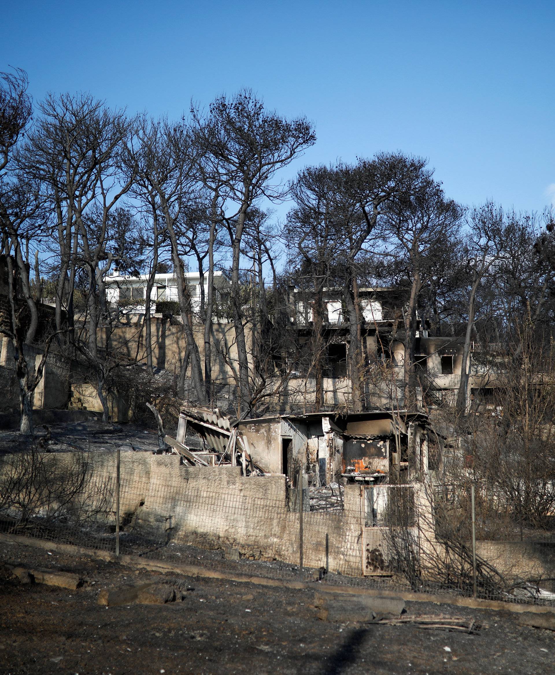 Burnt houses are seen following a wildfire at the village of Mati