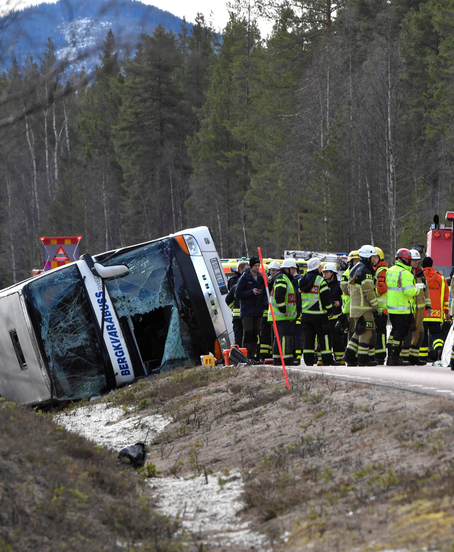 Rescue workers are seen at the site where a bus carrying school children and adults rolled over on a road close to the town of Sveg