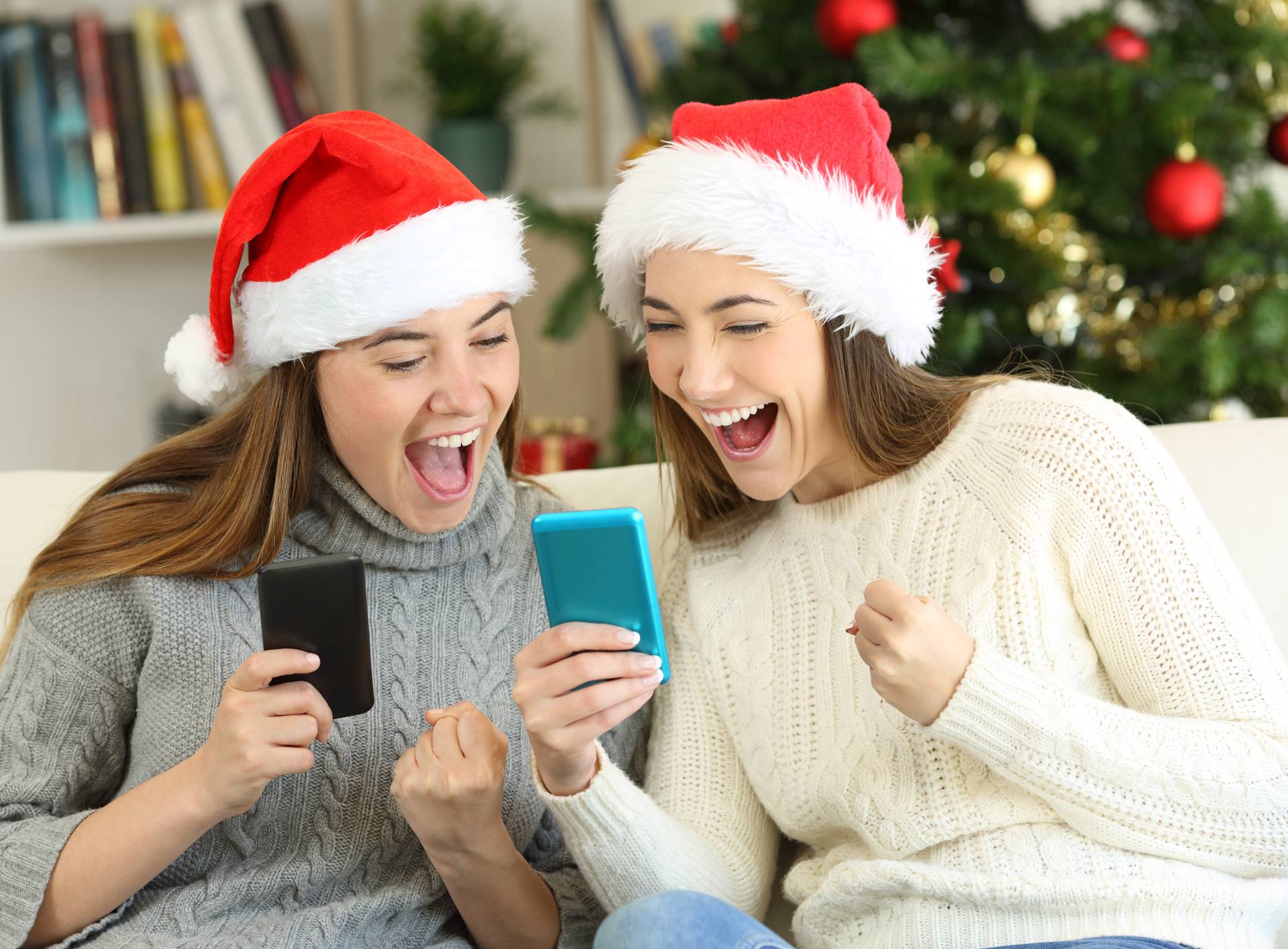 Excited friends watching phone content on christmas
