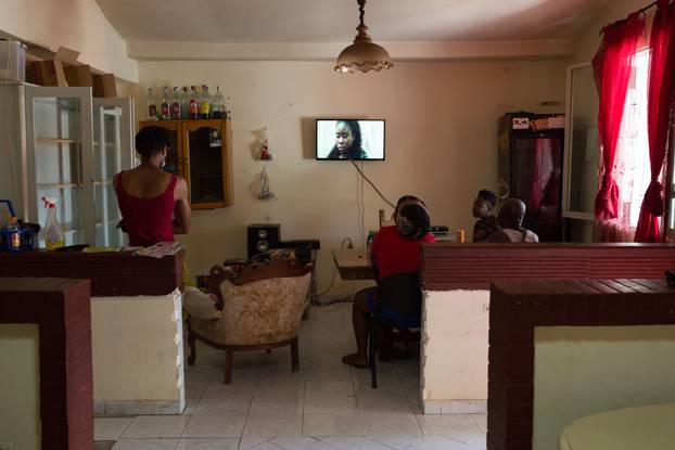 Migrants watching a TV series on Nigerian channel ROK in a connection house in Castel Volturno, Italy on August 23, 2018. Thomson Reuters Foundation / Valerio Muscella