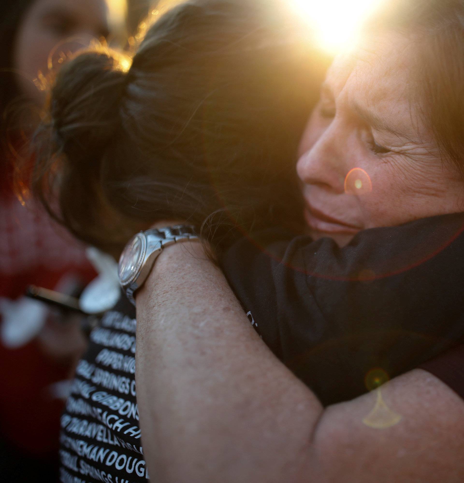 Women react during a candlelight vigil for victims of yesterday's shooting at nearby Marjory Stoneman Douglas High School, in Parkland