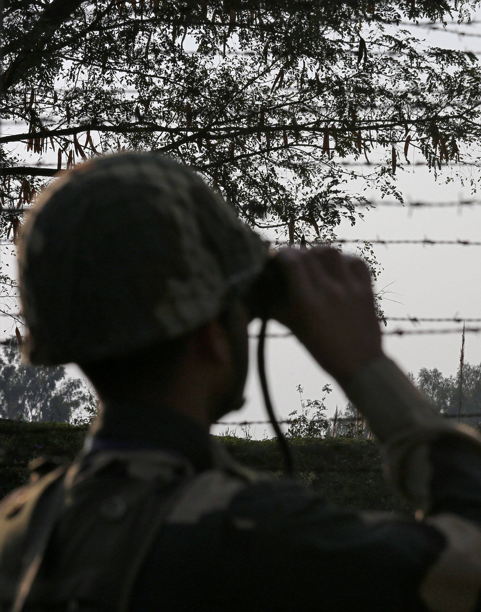 FILE PHOTO: An India's Border Security Force soldier keeps vigil during patrol along the fenced border with Pakistan in Ranbir Singh Pura sector
