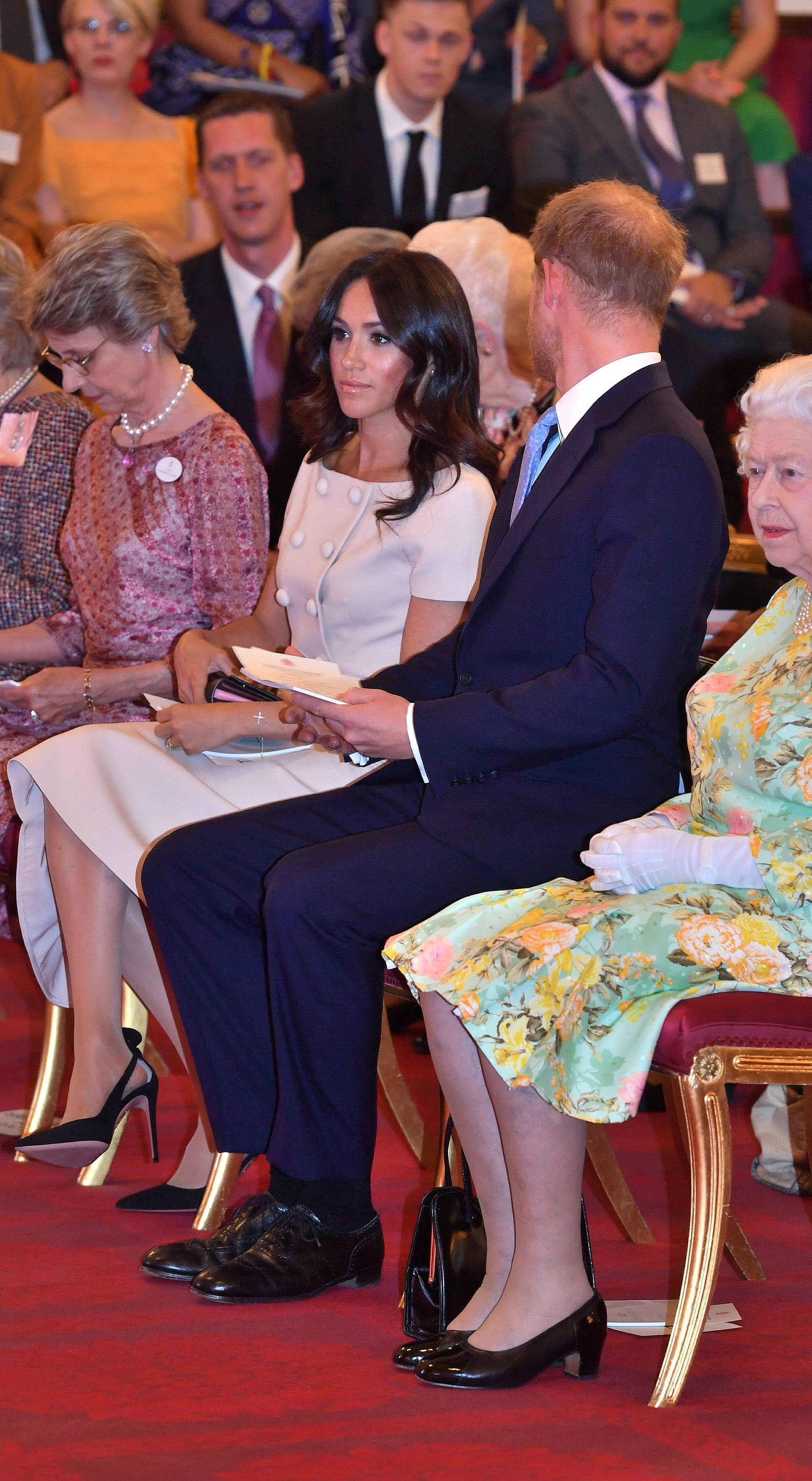 Britain's Queen Elizabeth, Prince Harry and Meghan, the Duchess of Sussex attend reception following the final Queen's Young Leaders Awards Ceremony at Buckingham Palace in London