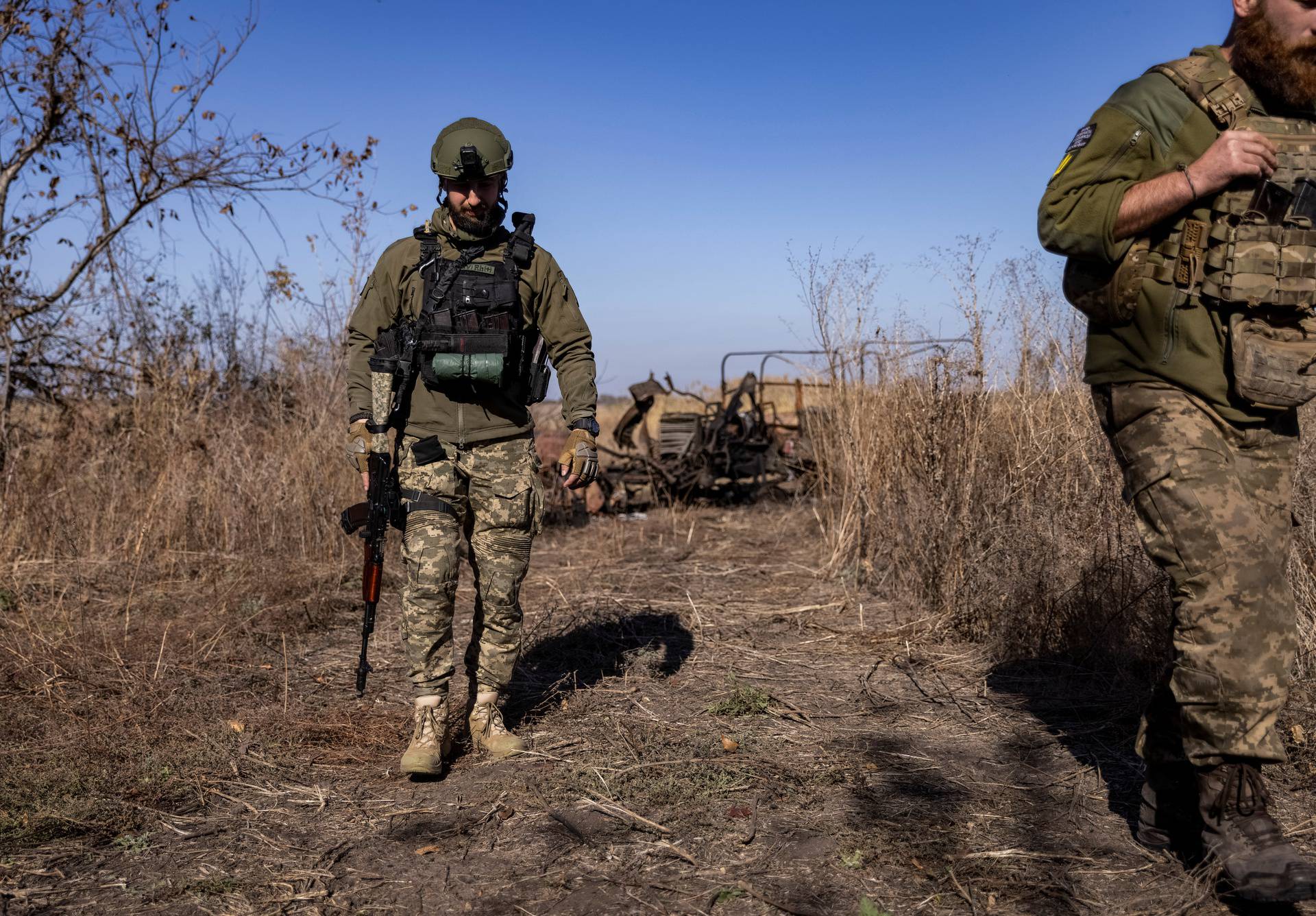 Ukrainian servicemen walk at a position near a frontline in Donetsk region