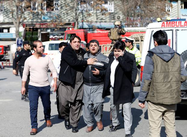 People assist an injured man after a blast in Kabul