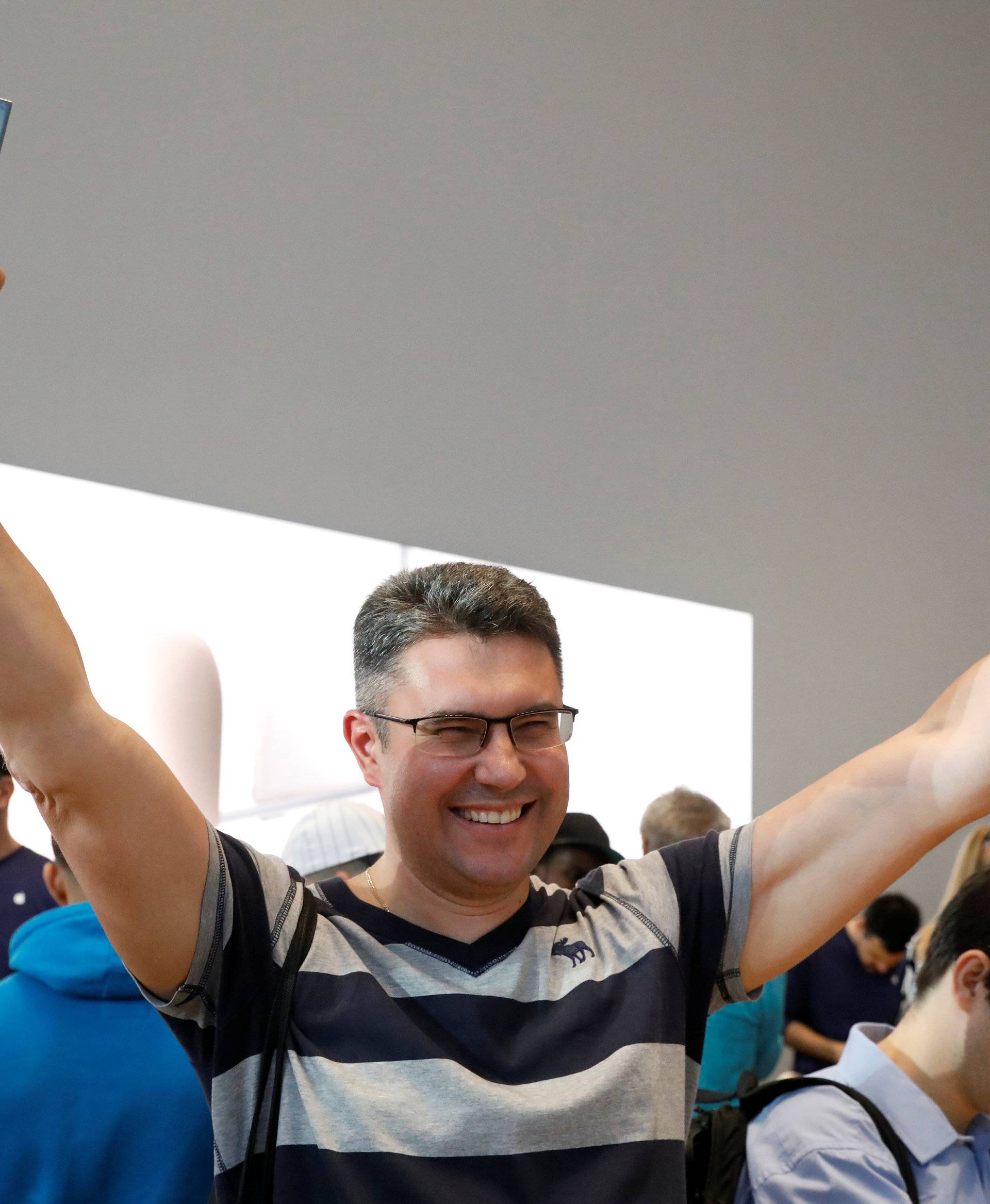 One of the first customers celebrates his purchase of the new iPhone 8 at the 5th Avenue Apple store in New York