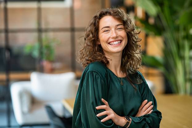 Portrait,Of,Young,Smiling,Woman,Looking,At,Camera,With,Crossed