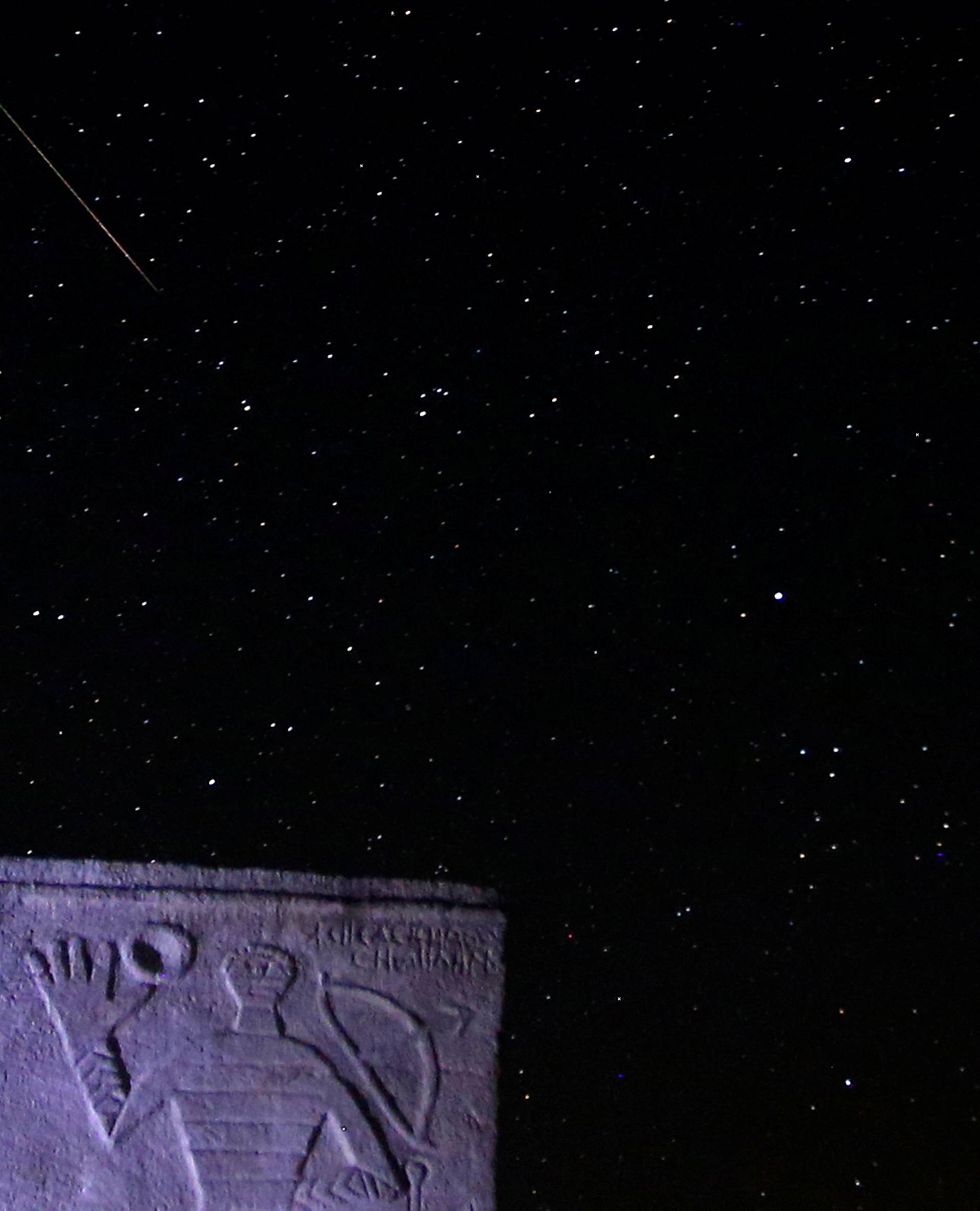 A meteor streaks past stars in the night sky above medieval tombstones in Radmilje near Stolac, south of Sarajevo