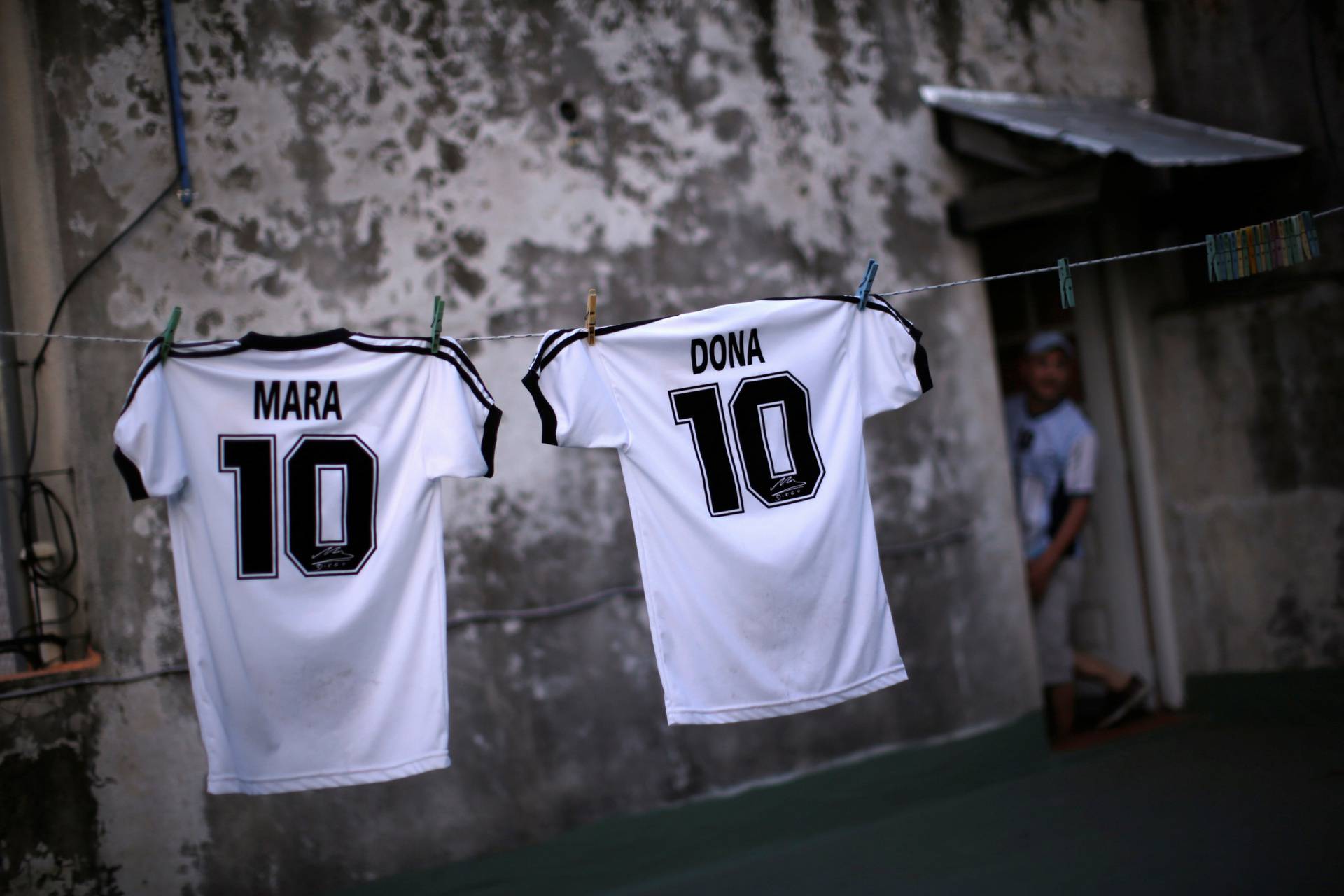 T-shirts with the names of Mara and Dona, twin daughters of Walter Gaston Rotundo, a devoted Diego Maradona fan that named his daughters after the soccer star, are seen on the clothesline at the family house, in Buenos Aires