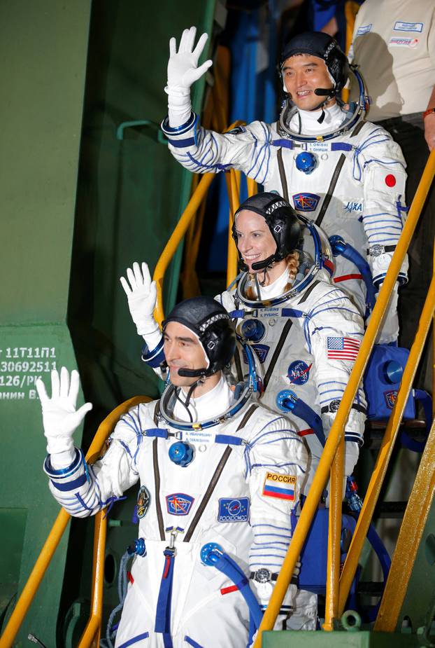 The International Space Station (ISS) crew members Kate Rubins of the U.S., Anatoly Ivanishin of Russia and Takuya Onishi of Japan gesture close to the rocket prior the launch at the Baikonur cosmodrome, Kazakhstan