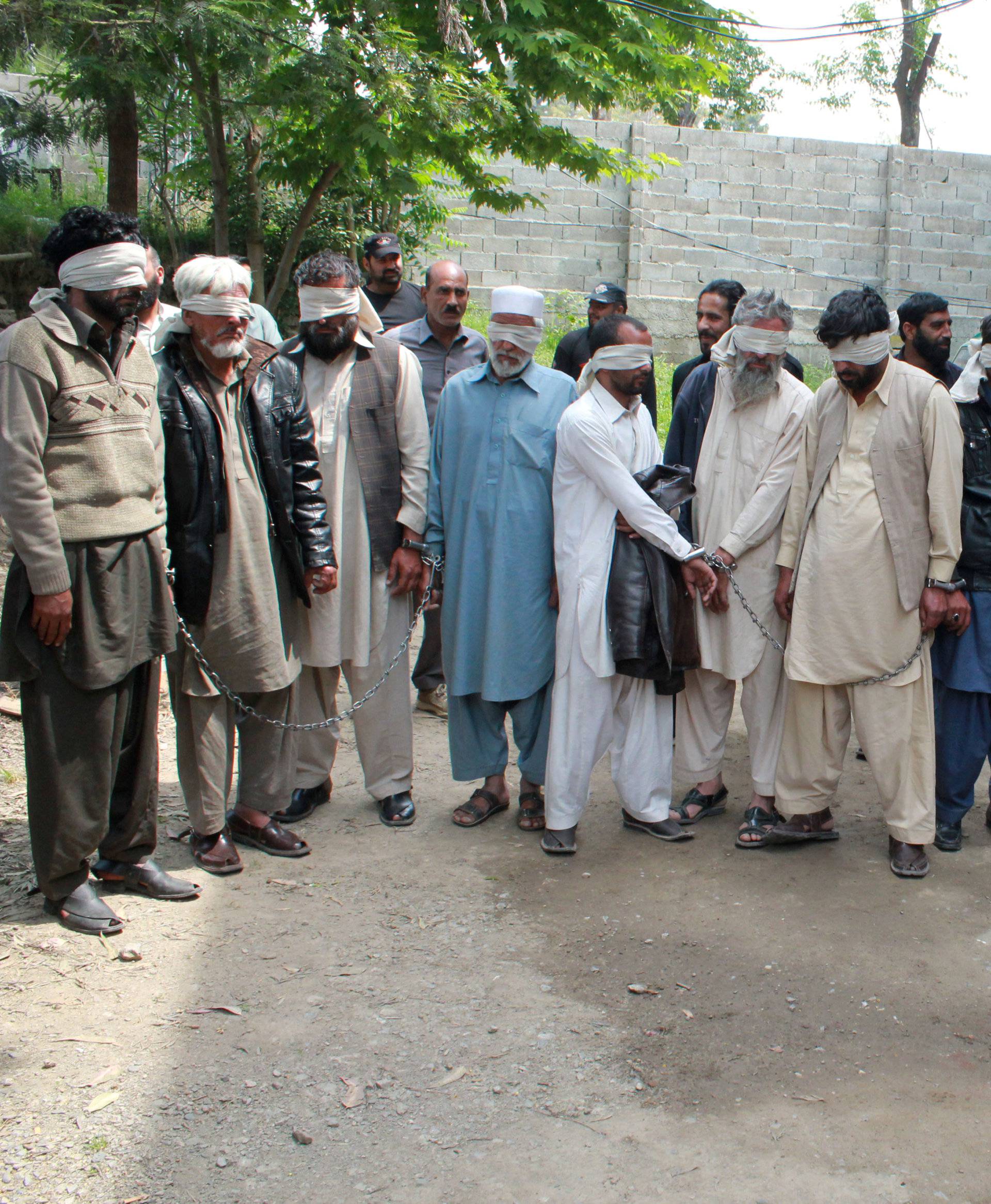 Members of a tribal council accused of ordering the burning death of a 16 year old girl are shown to the media after they were arrested by police in Donga Gali, outside Abbottabad