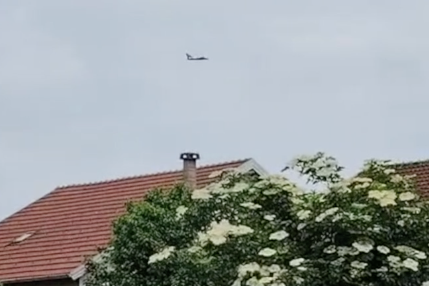 Vojni avion leti nisko iznad kuća