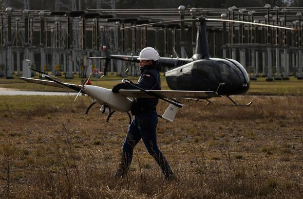 FILE PHOTO: Polish transmission system operator PSE worker carries a drone used to monitor power lines, part of the route of the LitPol, the interconnection between Poland and Lithuania near Elk