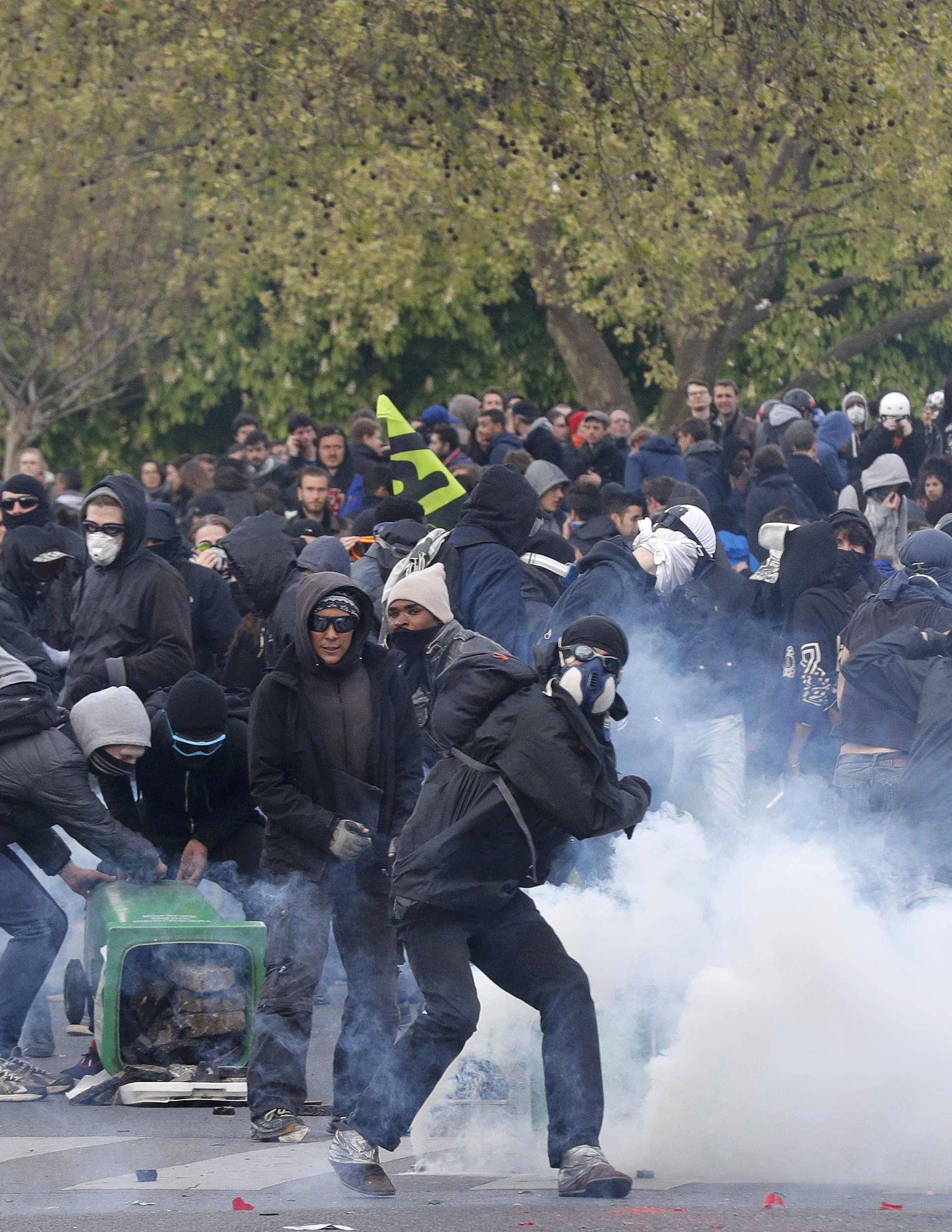 Masked youths face off with French police during a demonstration against the French labour law proposal in Paris