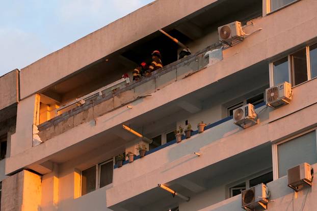 Firefighters and law enforcement work on the site of an explosion at a residential block of flats following a drone hit close to the border with Ukraine