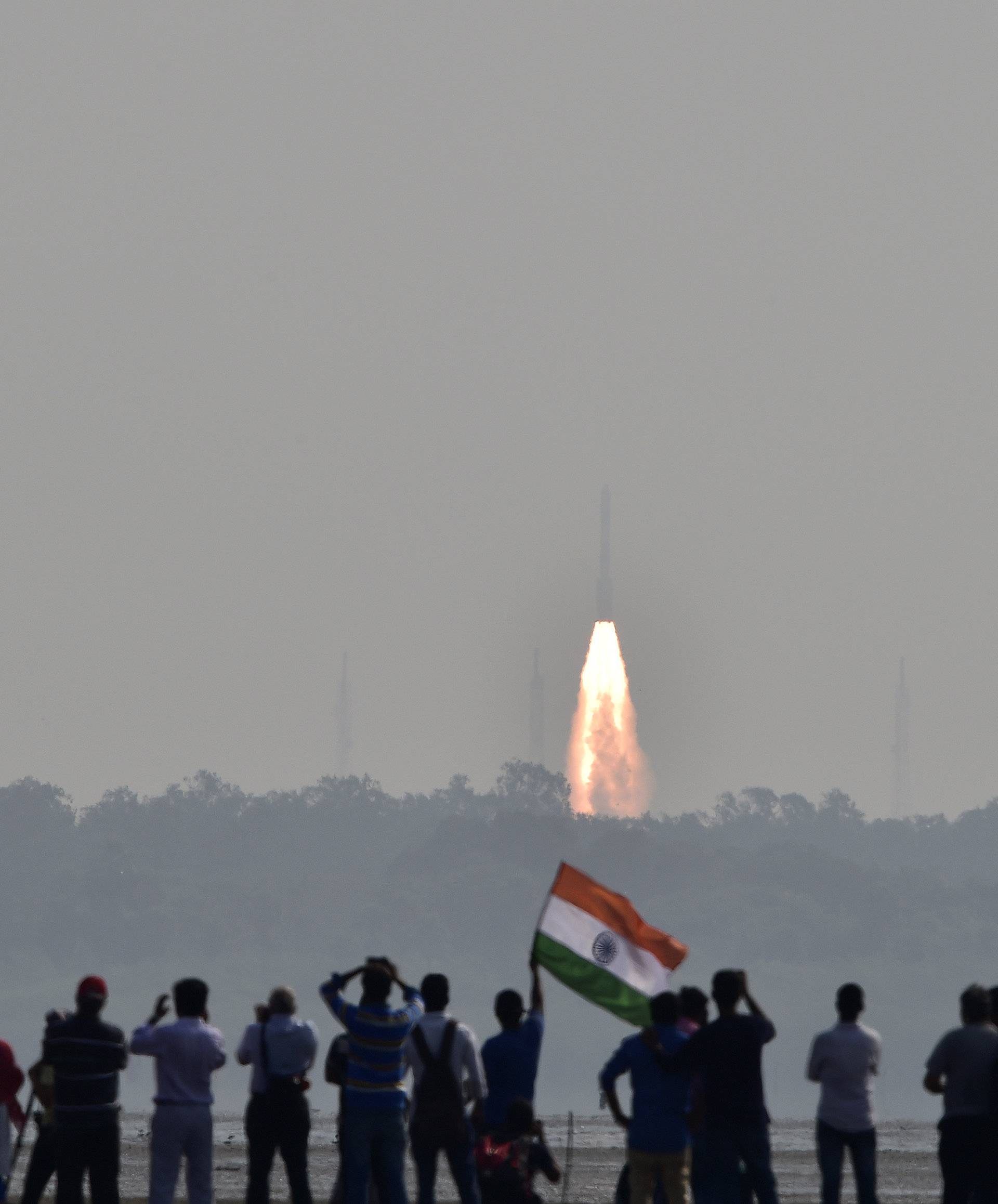People watch as India's PSLV-C37 carrying 104 satellites in a single mission lifts off from the Satish Dhawan Space Centre in Sriharikota