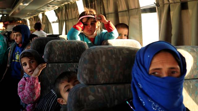 People, who just fled a village controled by Islamic State militants, sit inside a bus before heading to a camp at Hammam Ali, south of Mosul