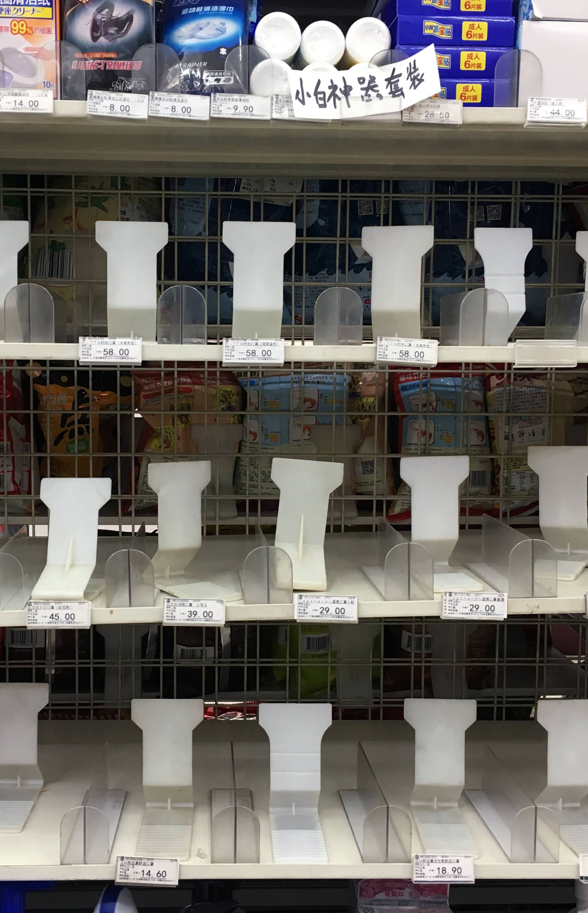 Pack of mask is seen on an empty shelf that used to display masks for sale at a store in Beijing