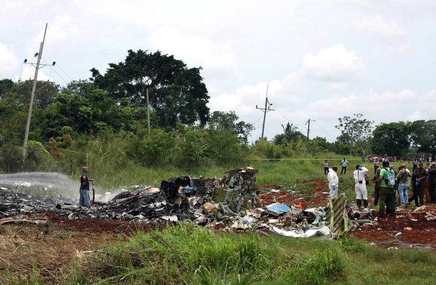 Rescue team members work in the wreckage of a Boeing 737 plane that crashed in the agricultural area of Boyeros