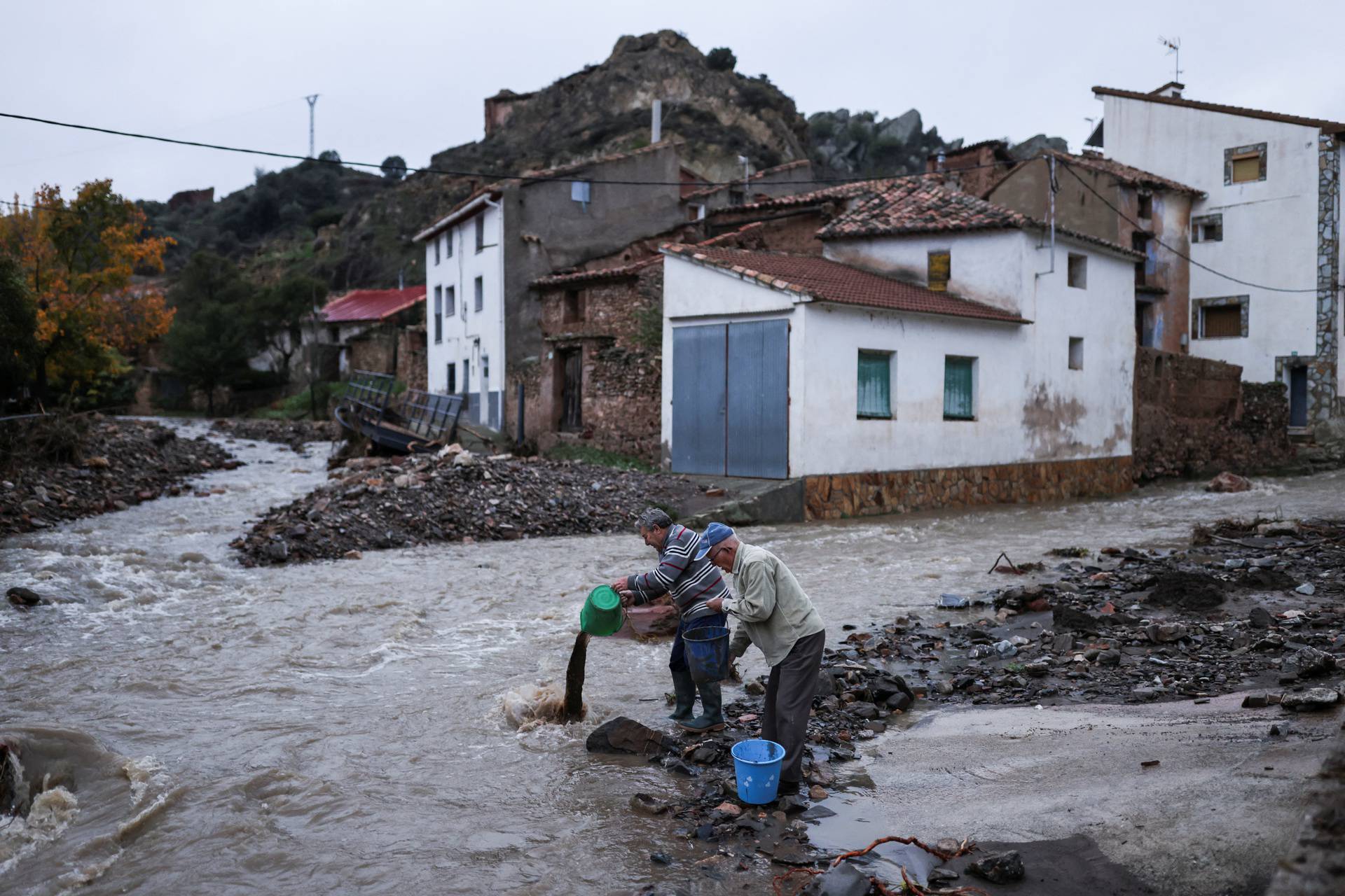 People hold buckets, after heavy rains caused flooding, in La Hoz de la Vieja