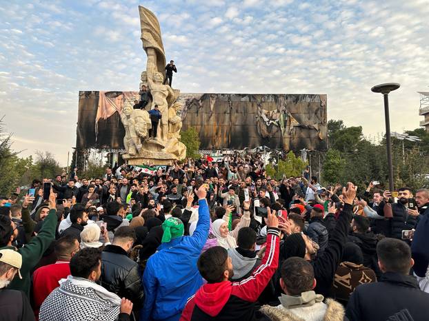 People gather at Saadallah al-Jabiri Square as they celebrate, in Aleppo