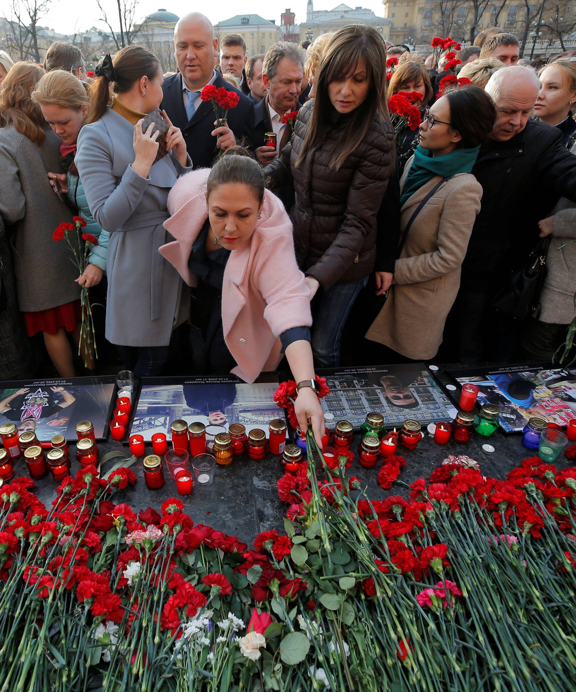 People attend a memorial to pay tribute to the victims of the St. Petersburg metro blast in central Moscow