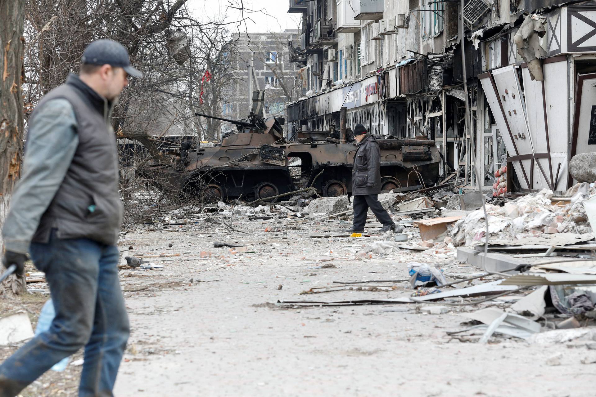 Local residents walk in a courtyard in the besieged city of Mariupol