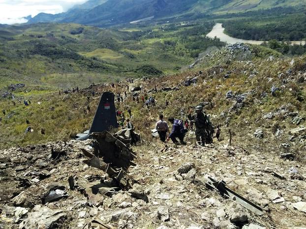 Rescue teams and locals are seen at the crash site of Indonesian air force transport plane which killed all 13 people board, on Mount Lisuwa, near Wamena in the remote region of Papua, Indonesia