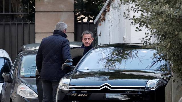 Former French President Nicolas Sarkozy enters his car as he leaves his house in Paris