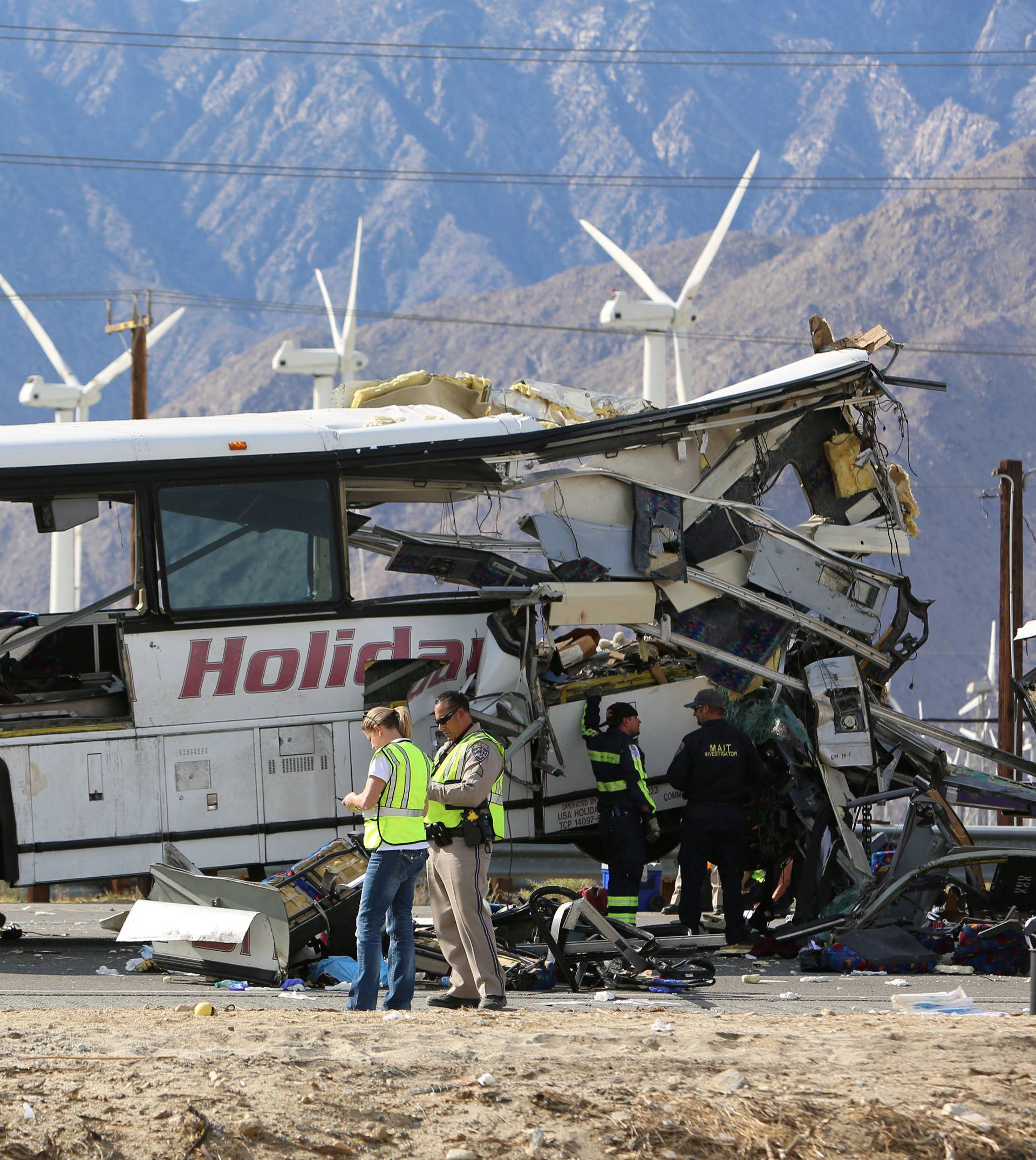 Investigators confer at the scene of a mass casualty bus crash on the westbound Interstate 10 freeway near Palm Springs, California