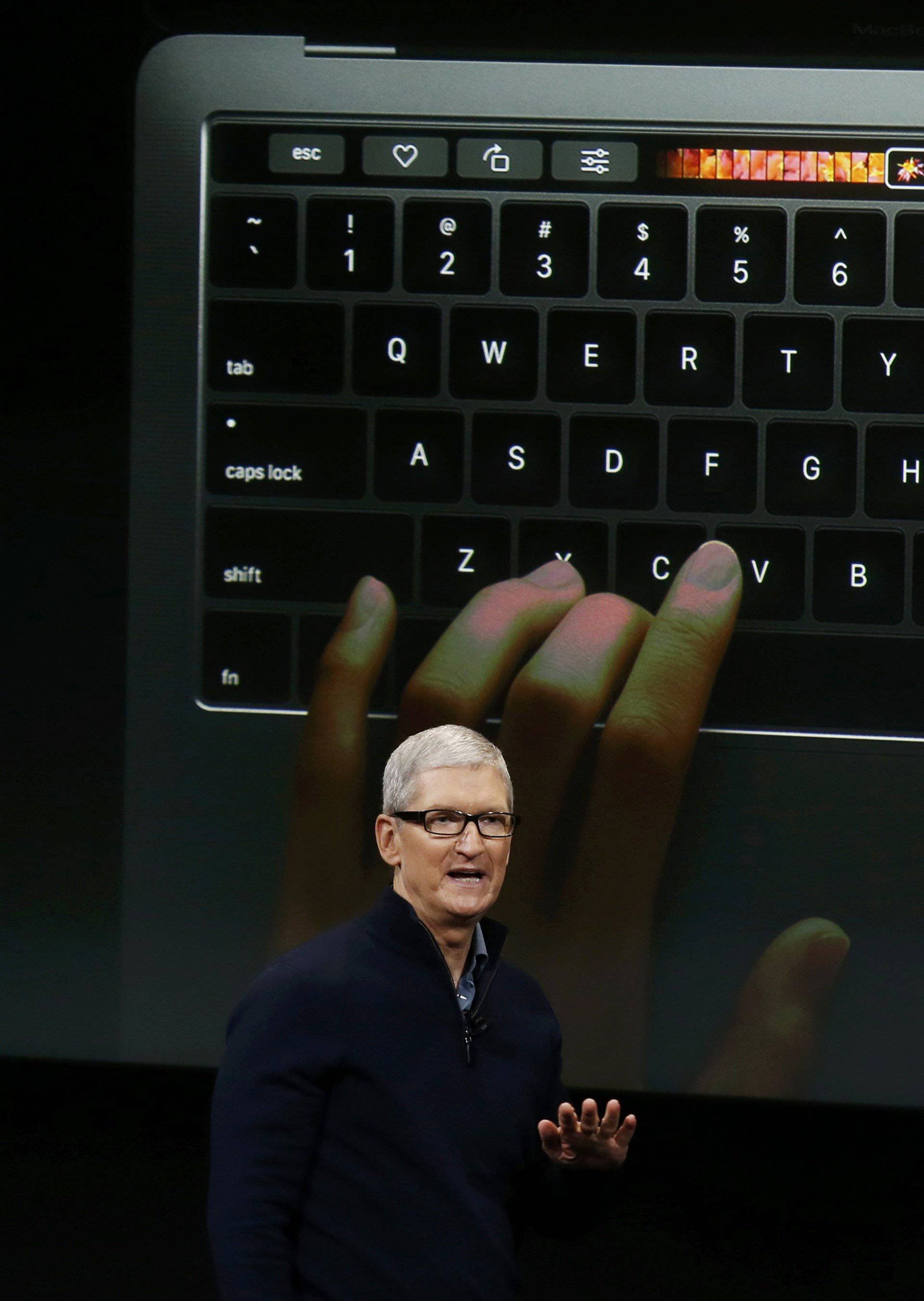Apple CEO Tim Cook speaks under a graphic of the new MacBook Pro during an Apple media event in Cupertino