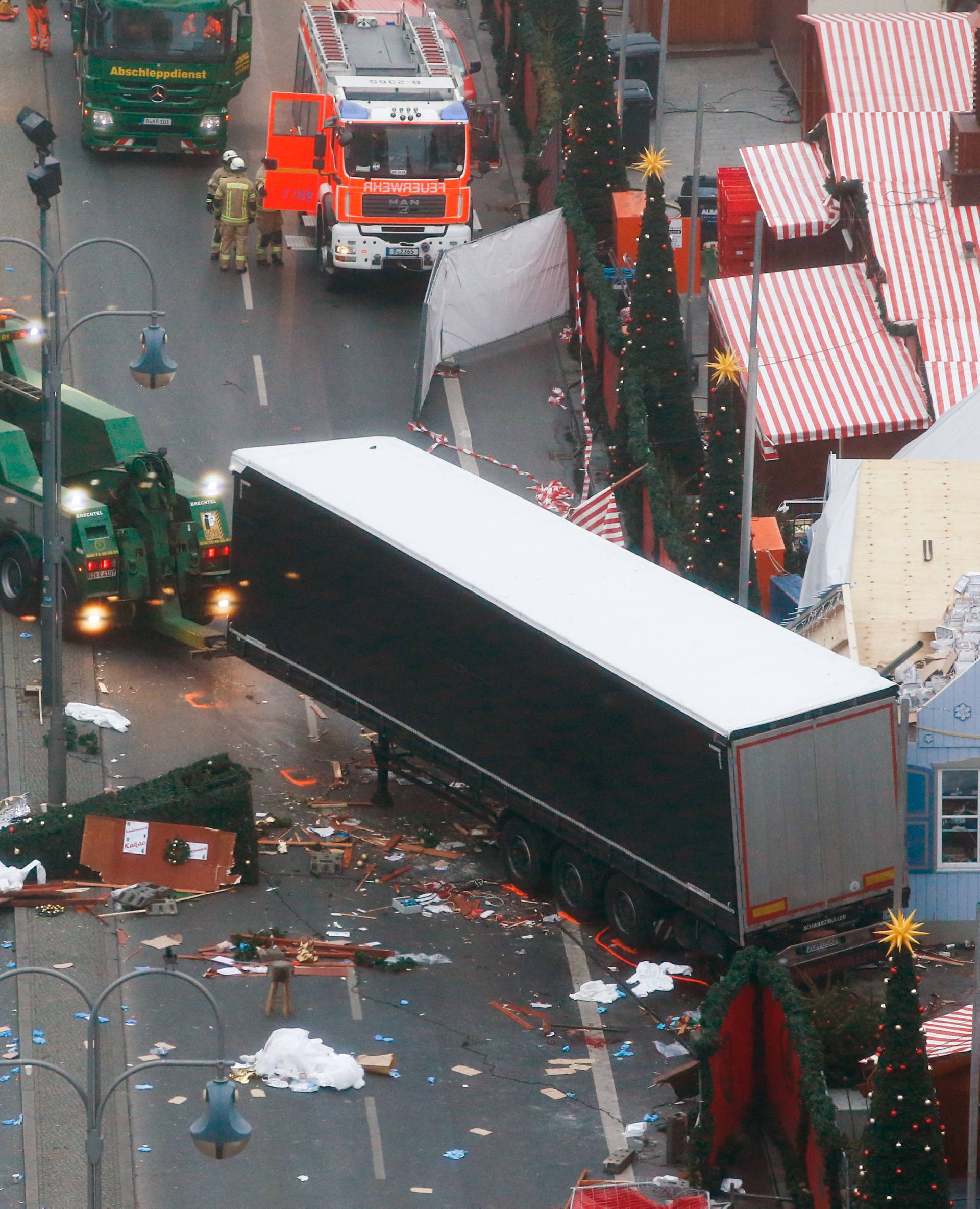 Rescue workers tow the truck which ploughed into a crowded Christmas market in the German capital last night in Berlin