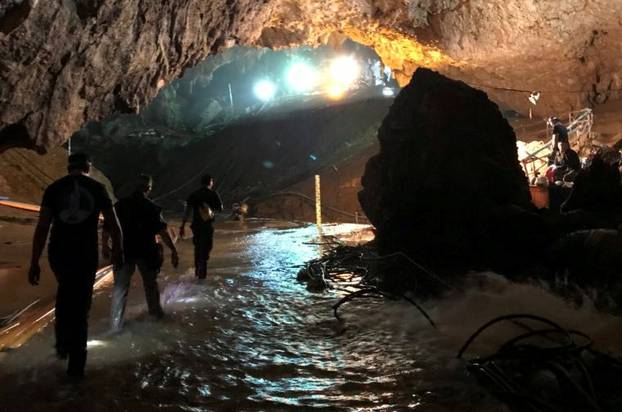 Rescue personnel walk in a cave at the Tham Luang cave complex during a mission to evacuate the remaining members of a soccer team trapped inside, in Chiang Rai