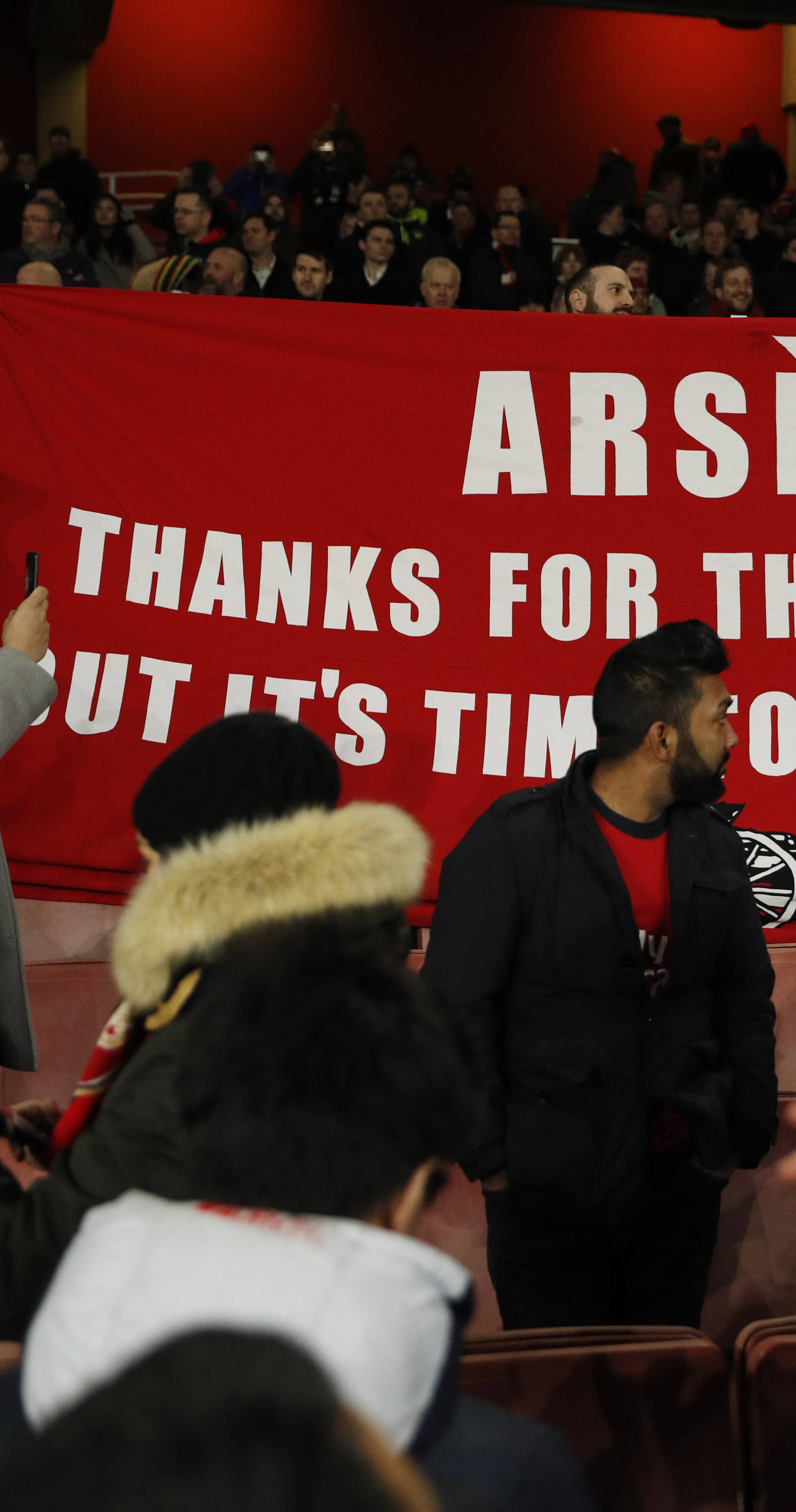 Arsenal fans hold up a banner protesting against Arsenal manager Arsene Wenger after the game