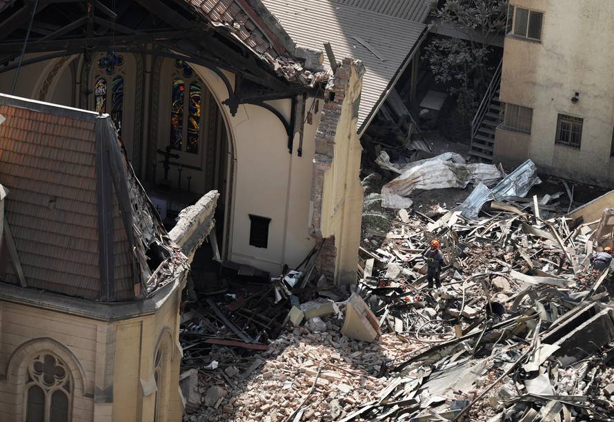 A firefighter looks at a church and a building that caught fire and collapsed in the center of Sao Paulo