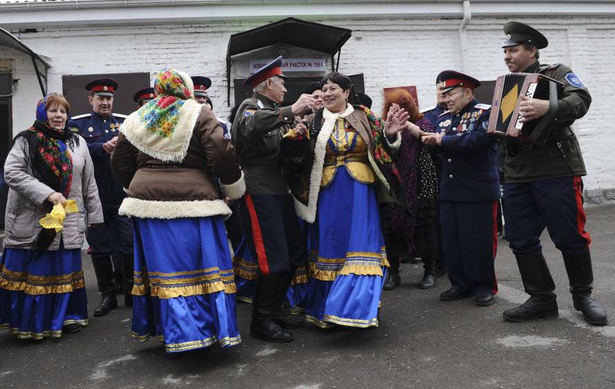 Members of a local Cossack community dance outside a polling station during the presidential election in Rostov-on-Don