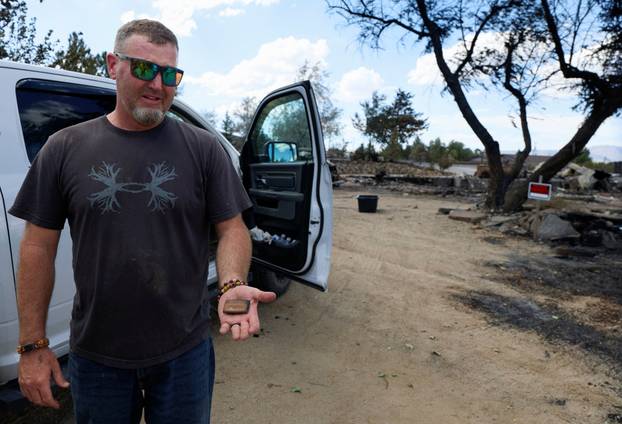 Luke Opperman shows item he recoverd from burned home at Hawk Fire in Reno