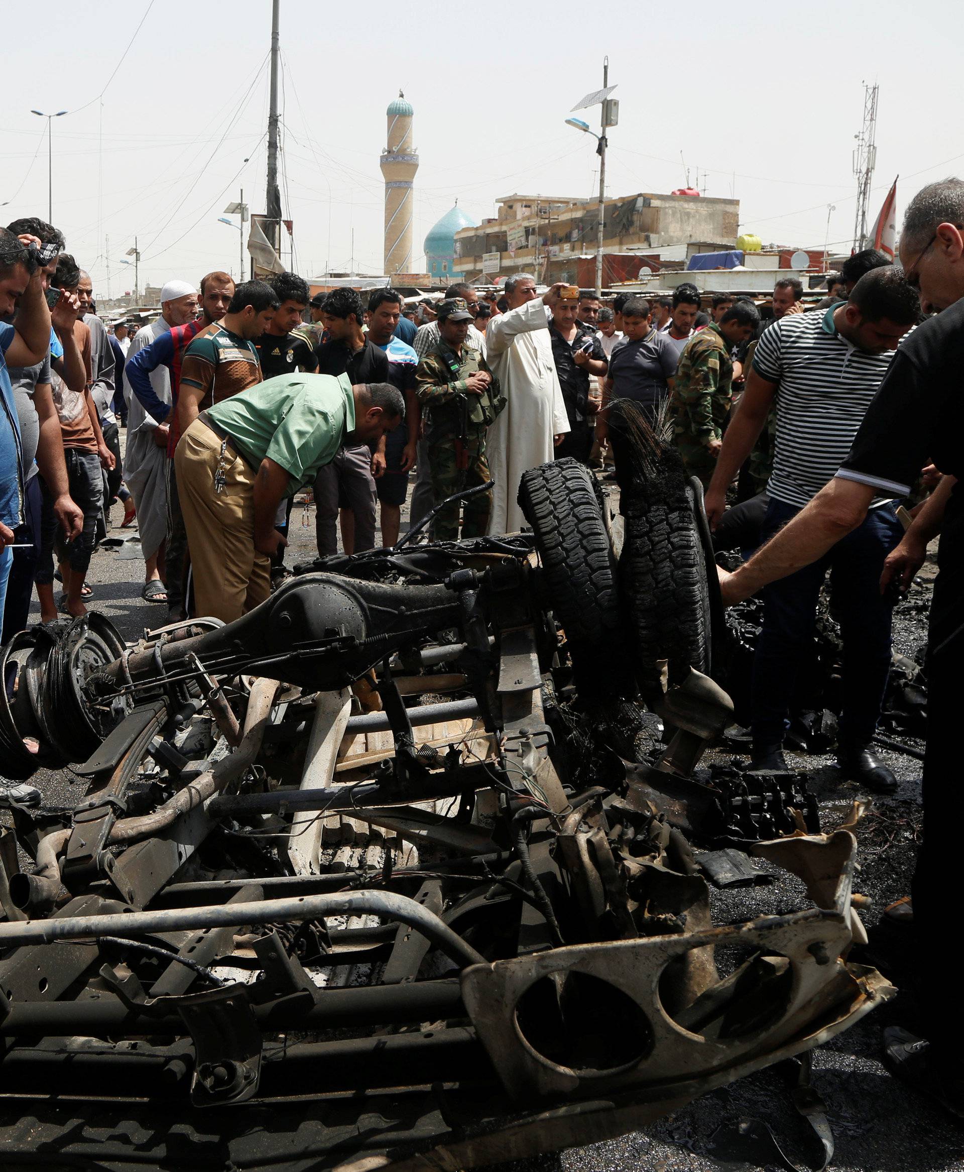 People gather at the scene of a car bomb attack in Baghdad's mainly Shi'ite district of Sadr City