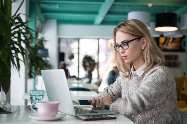 Busy female student preparing for exam in cafe