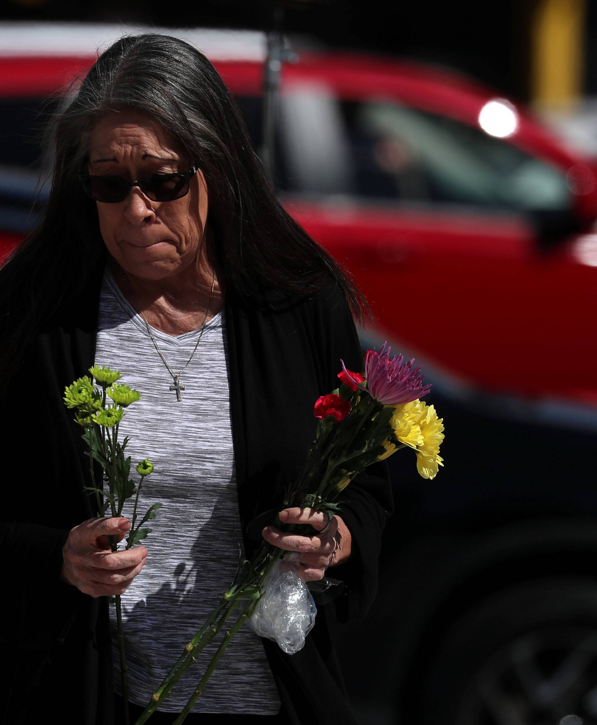 A woman leaves flowers at a makeshift memorial along Las Vegas Boulevard following a mass shooing in Las Vegas