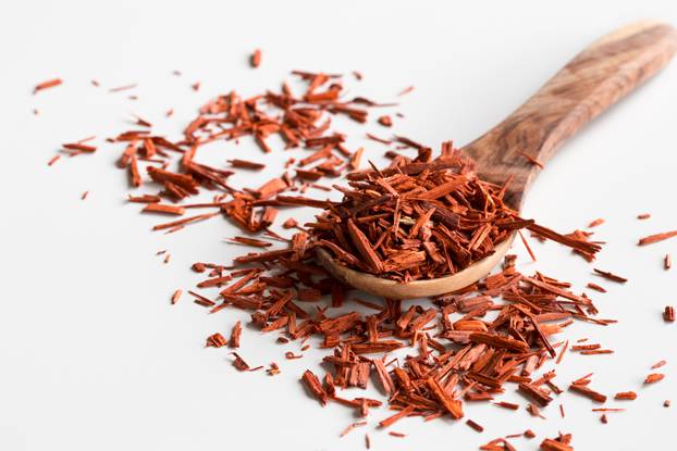 Pieces of sandalwood on a wooden spoon on a white background