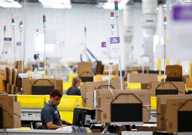 FILE PHOTO: Employees work at packing stations on the main floor at the Amazon fulfillment center in Kent