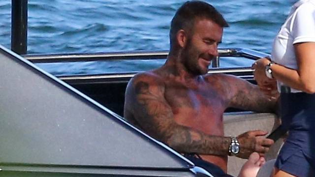 EXCLUSIVE: David Beckham looks happy as he shows off his tanned torso while spending yet another day on his yacht in Miami