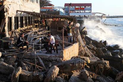 Palestinians smoke a water pipe at the site of an Israeli airstrike in Gaza