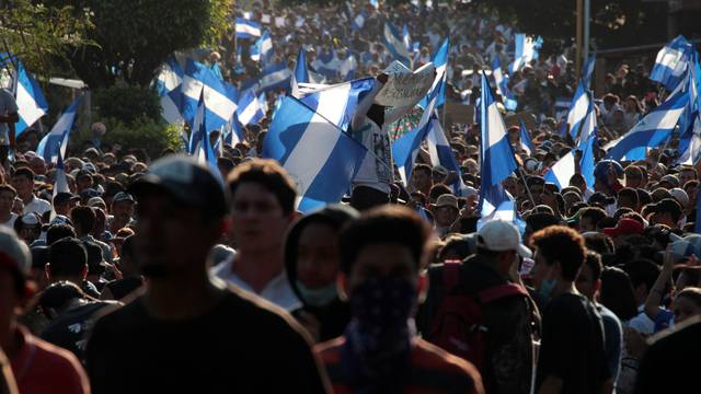 Demonstrators wave flags during a protest against police violence and the government of Nicaraguan President Daniel Ortega in Managua