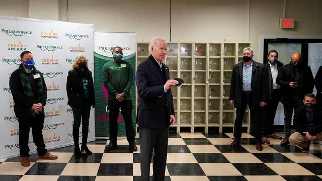 U.S. President Joe Biden fills boxes at a food bank in Philadelphia, Pennsylvania