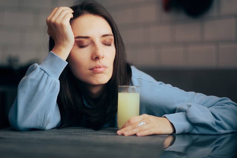 Tired Woman Having An Effervescent Drink Of Calcium And Magnesiu