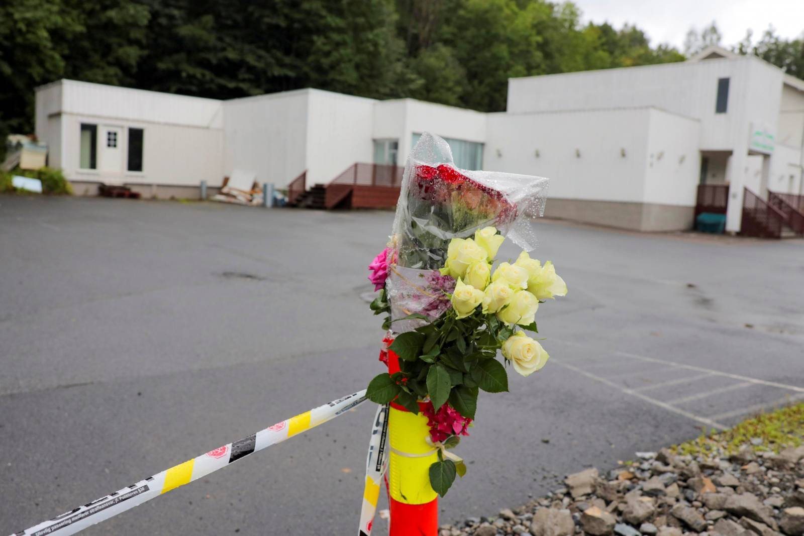 Flowers and a police tape are seem outside Al-Noor Islamic Centre Mosque, a day after a gunman's attack, in Baerum outside Oslo