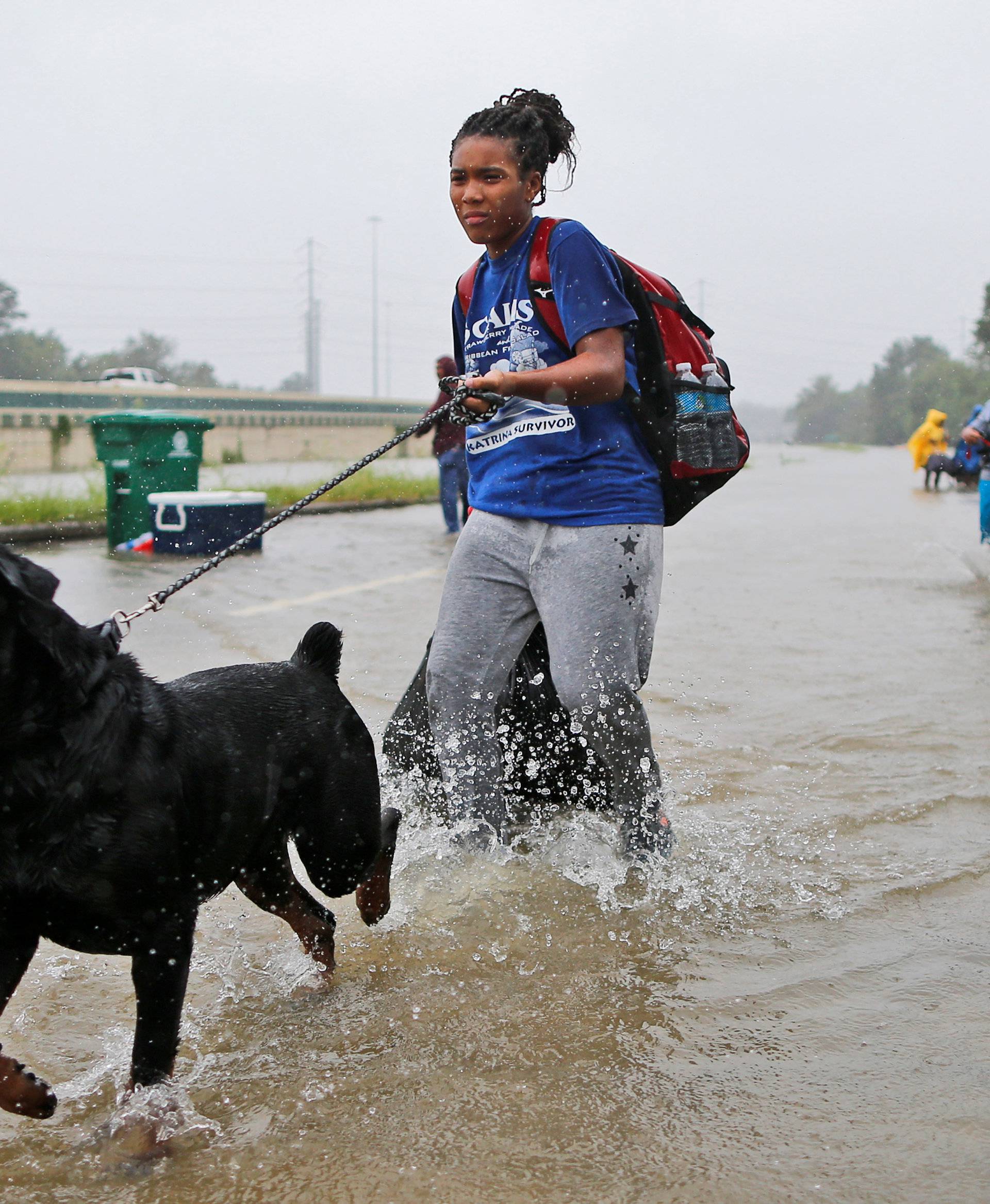 Scales and her dog wade through flood waters from Tropical Storm Harvey in Beaumont Place